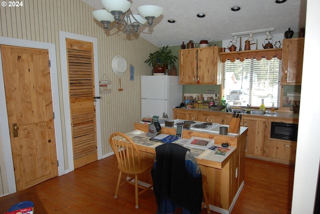 kitchen with dark hardwood / wood-style floors, black microwave, a notable chandelier, and white refrigerator