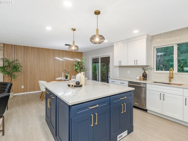 kitchen with white cabinets, tasteful backsplash, stainless steel dishwasher, blue cabinetry, and pendant lighting