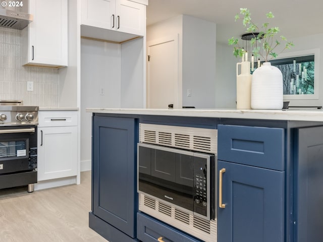 kitchen with blue cabinetry, stainless steel appliances, and white cabinets