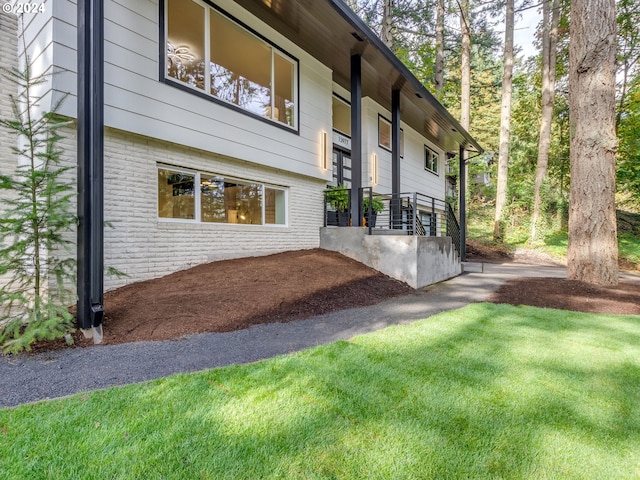 view of property exterior with a patio area and a lawn