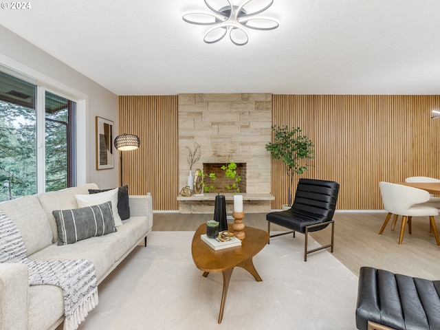 living room featuring a stone fireplace and wood-type flooring