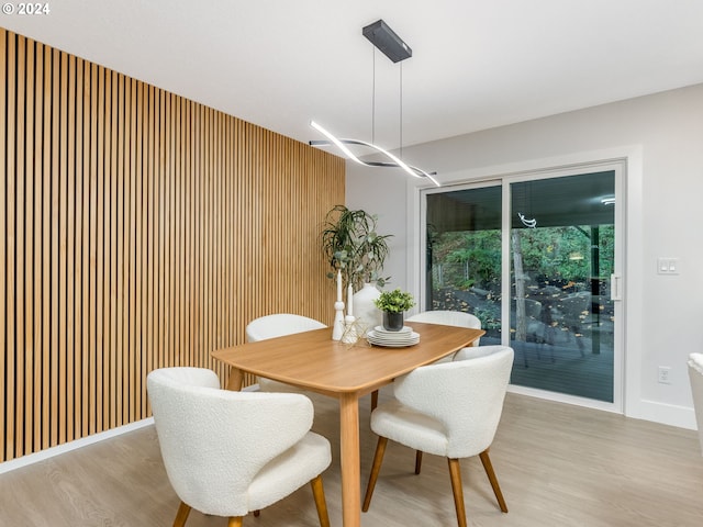 dining area featuring light hardwood / wood-style floors and wood walls