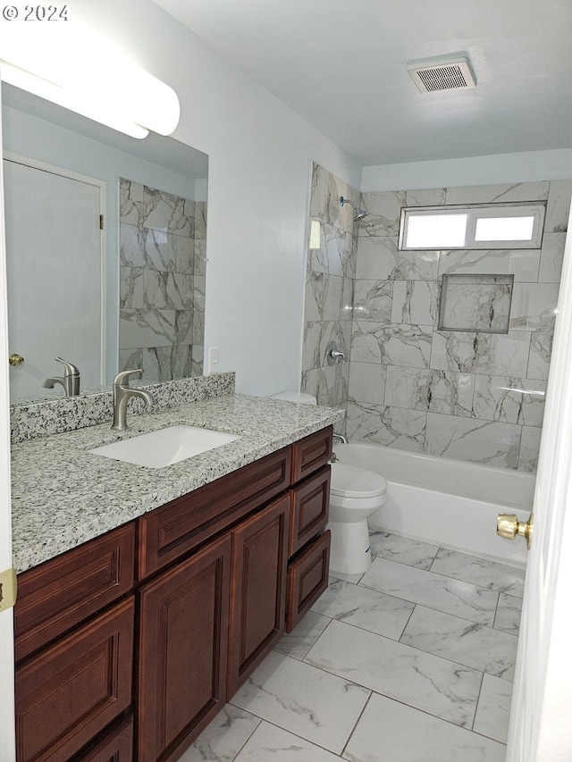 full bathroom featuring tiled shower / bath, toilet, and vanity