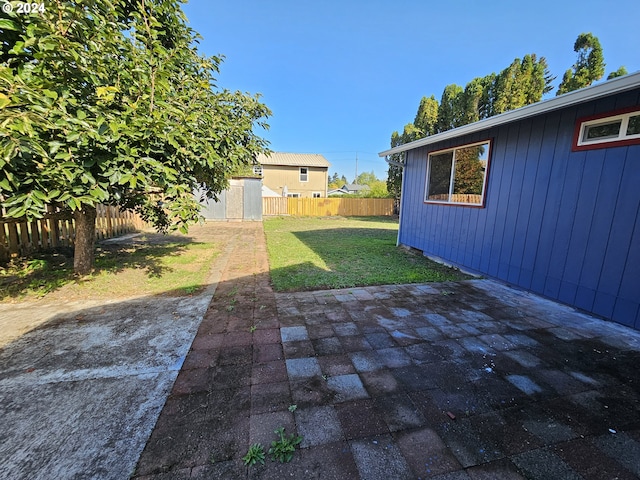 view of yard featuring a patio and a storage shed