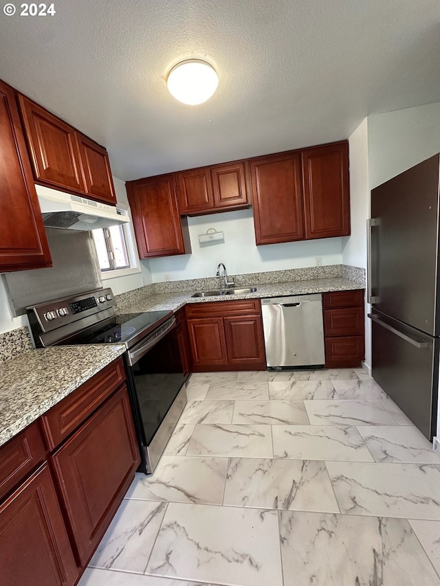 kitchen with stainless steel appliances, a textured ceiling, sink, and light stone counters