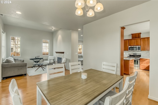 dining space featuring a chandelier, recessed lighting, and light wood-style floors