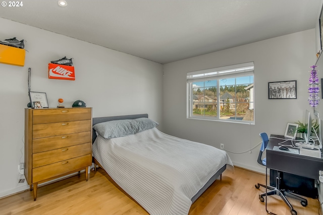 bedroom with light wood finished floors and baseboards