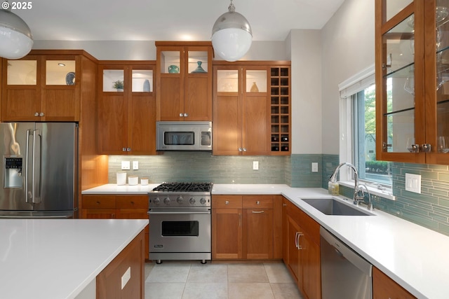 820 NW 12th Ave Unit 110, Portland, OR 97209 - kitchen featuring a sink, appliances with stainless steel finishes, brown cabinetry, light countertops, and light tile patterned floors