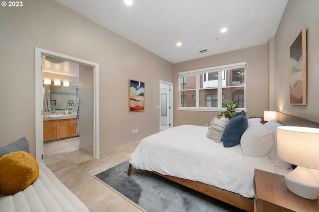 tiled bedroom featuring connected bathroom and sink