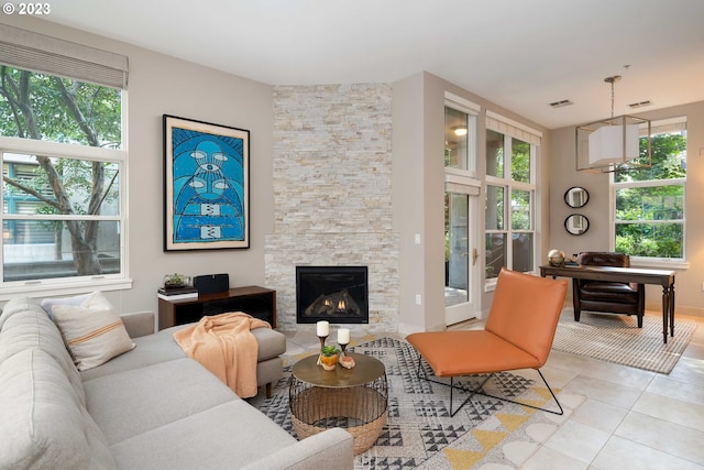 living room with a fireplace and light tile patterned floors