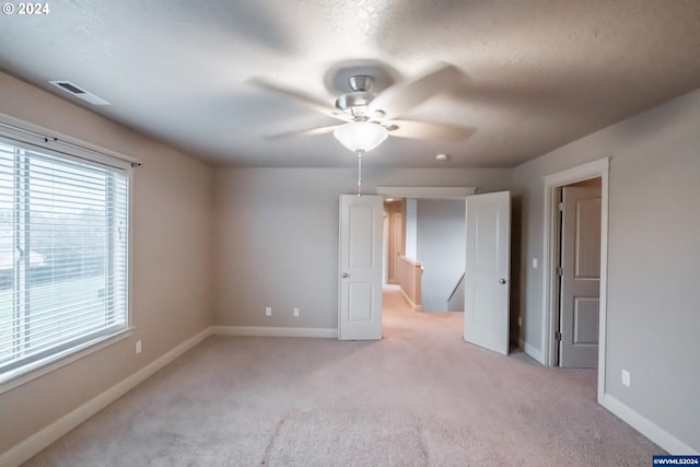 carpeted spare room with ceiling fan and a textured ceiling