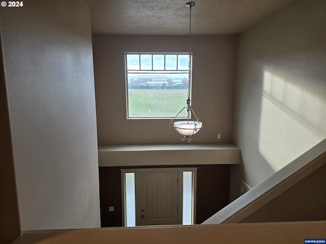 foyer entrance featuring a textured ceiling