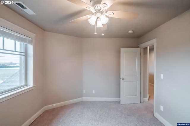 carpeted spare room with ceiling fan