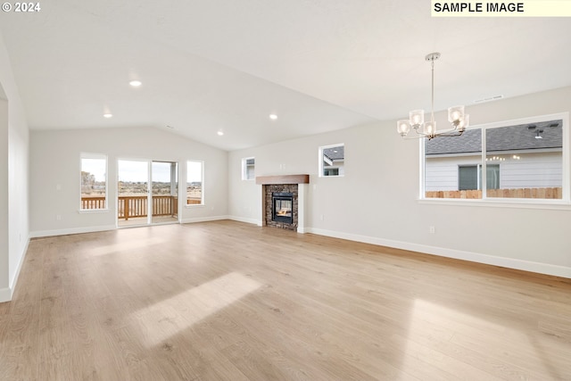 unfurnished living room featuring lofted ceiling, a fireplace, light hardwood / wood-style floors, and a notable chandelier