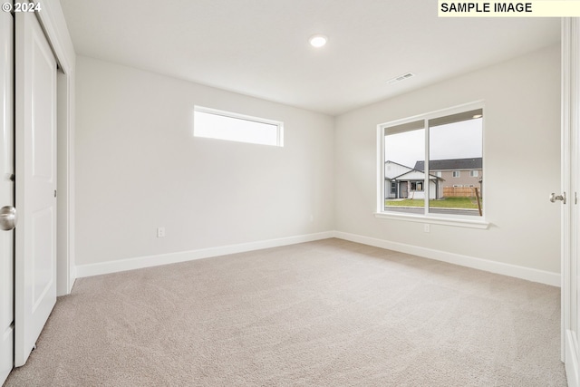 unfurnished bedroom with light carpet and a closet