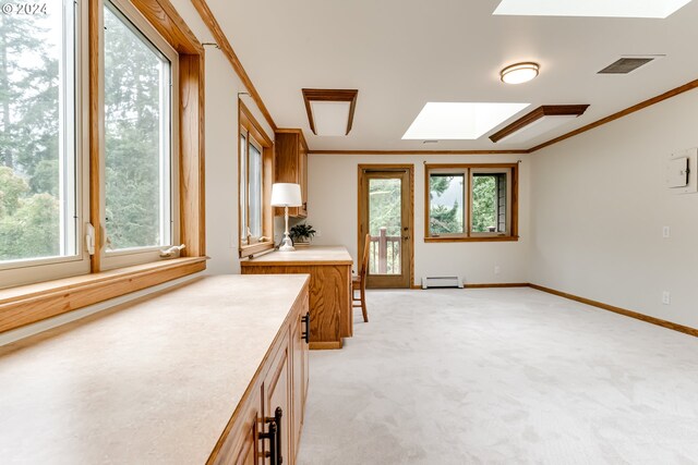 kitchen featuring ornamental molding, a skylight, light colored carpet, and baseboard heating