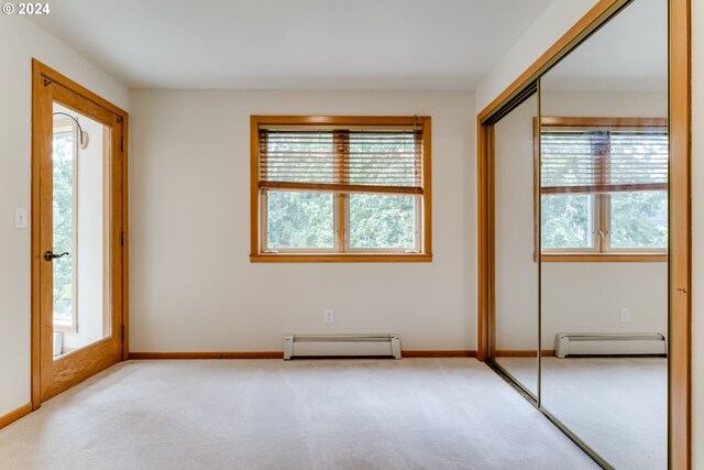 unfurnished bedroom with a baseboard radiator, a closet, and multiple windows