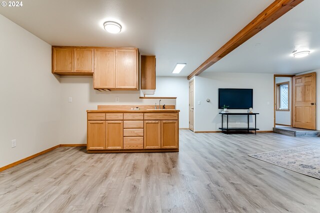 kitchen with light hardwood / wood-style floors, beam ceiling, light brown cabinets, and sink