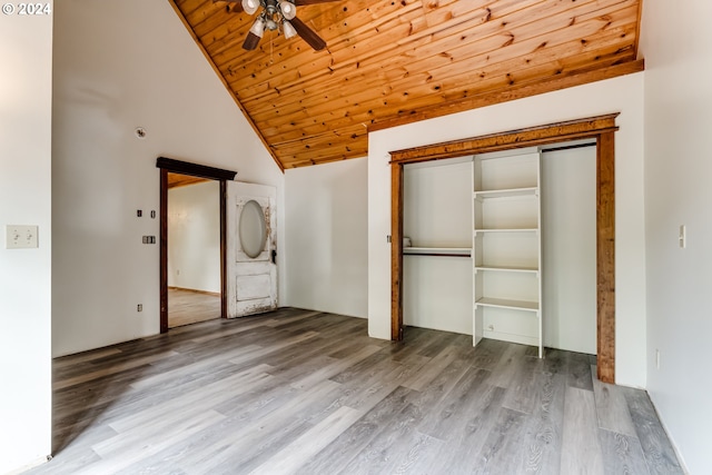 unfurnished bedroom with wood ceiling, a closet, hardwood / wood-style flooring, high vaulted ceiling, and ceiling fan