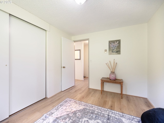 bedroom featuring wood finished floors, a closet, and a textured ceiling
