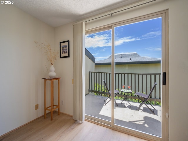 doorway to outside featuring wood finished floors and a textured ceiling