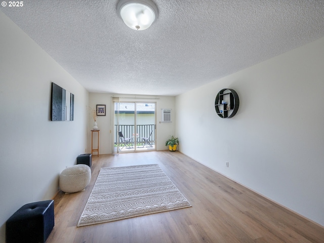 living area featuring wood finished floors and a textured ceiling