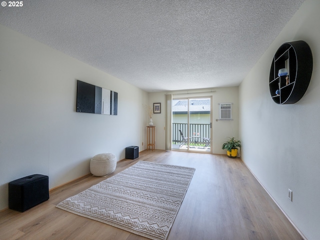 living area with wood finished floors and a textured ceiling