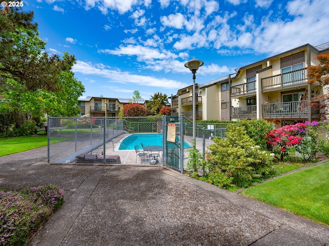 community pool with a gate and a residential view