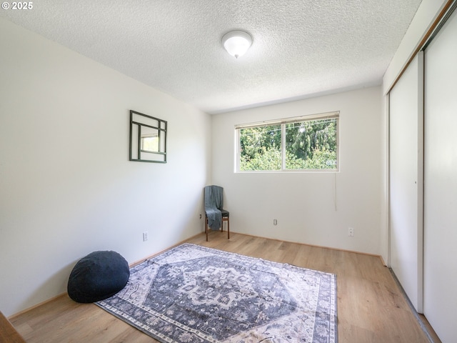 living area with light wood-style floors and a textured ceiling