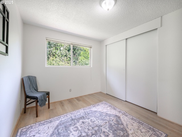 unfurnished room with wood finished floors and a textured ceiling