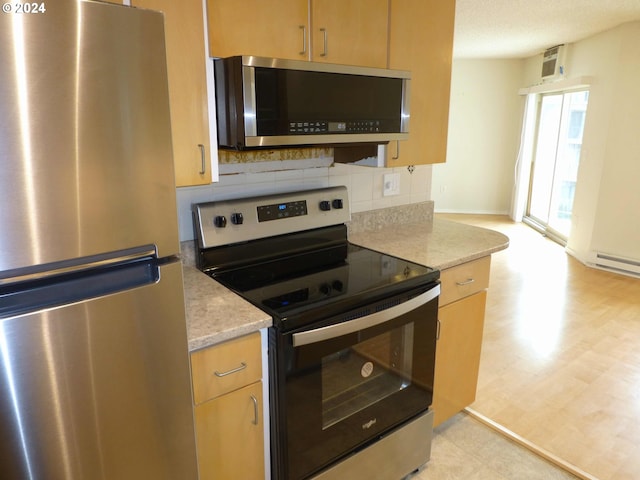 empty room with a healthy amount of sunlight, light hardwood / wood-style floors, ceiling fan, and a baseboard heating unit