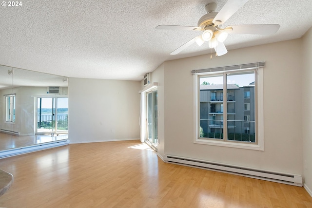 empty room with light wood-type flooring, ceiling fan, baseboard heating, and a wall mounted AC