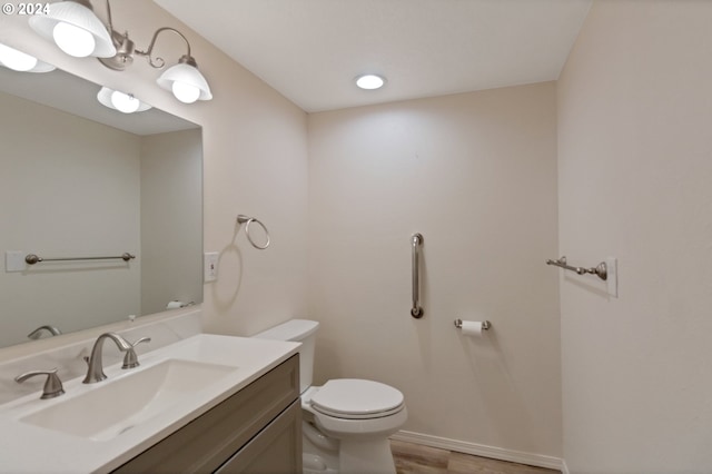 bathroom with vanity, toilet, and hardwood / wood-style flooring