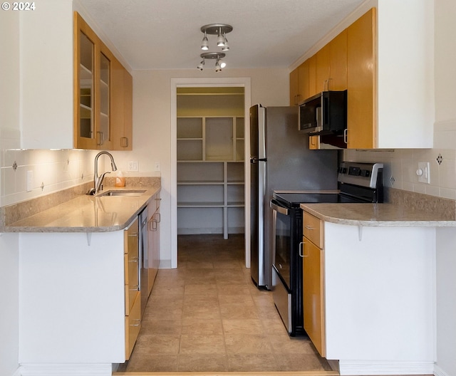 kitchen with light brown cabinets, stainless steel appliances, and decorative backsplash