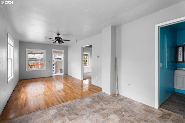 unfurnished living room featuring ceiling fan and tile patterned floors