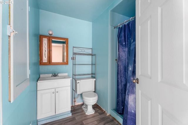 bathroom with toilet, walk in shower, vanity, and wood-type flooring