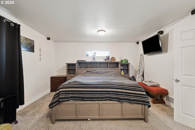 bedroom featuring light carpet, radiator heating unit, and baseboards