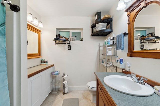 full bath featuring toilet, baseboards, vanity, and tile patterned floors