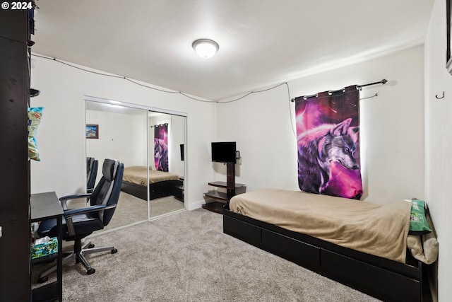 carpeted bedroom featuring baseboards and a closet