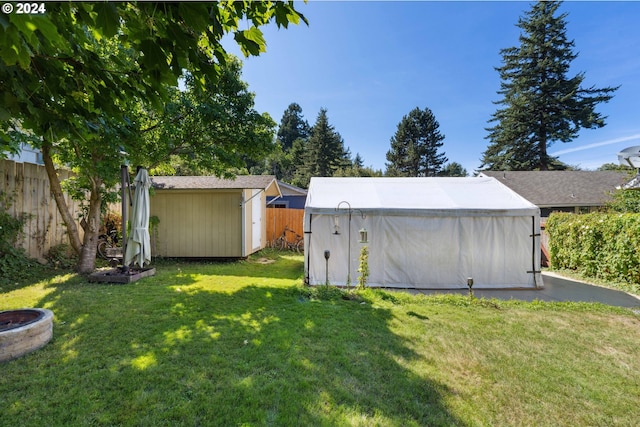 view of yard with a shed, an outdoor structure, and fence