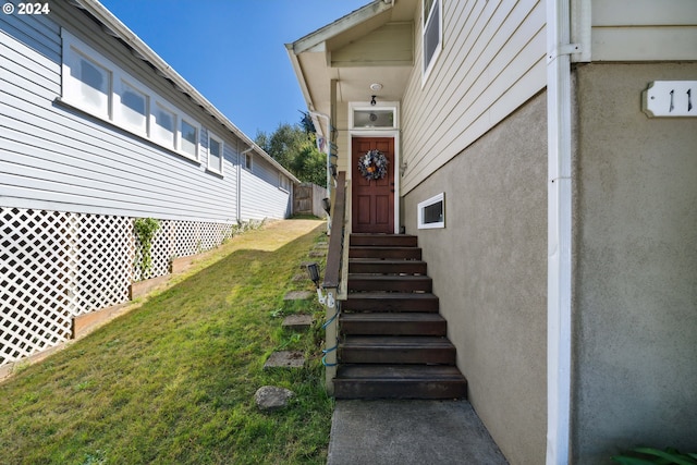 doorway to property with a yard and stucco siding