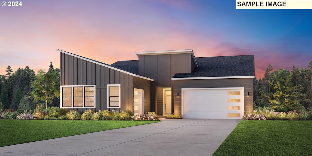 contemporary house featuring a garage and a lawn