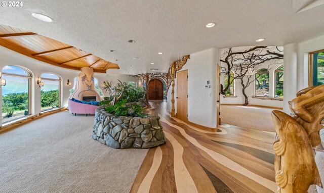 interior space featuring a wealth of natural light, light colored carpet, and a textured ceiling