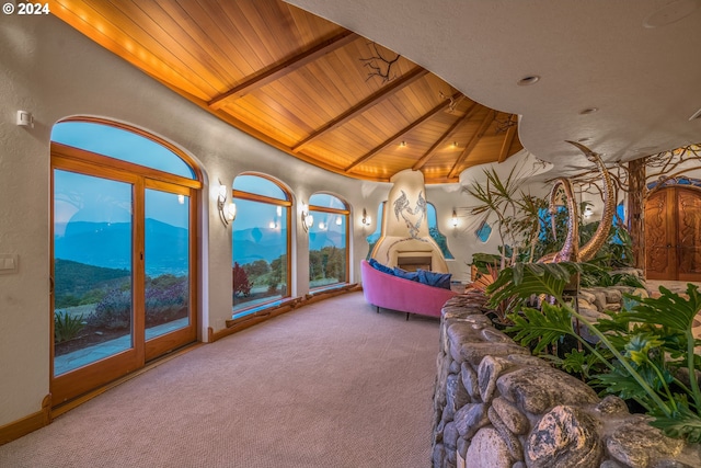 interior space featuring lofted ceiling with beams, a mountain view, carpet flooring, and wood ceiling