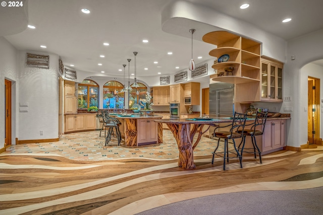 kitchen with built in appliances, pendant lighting, and a center island