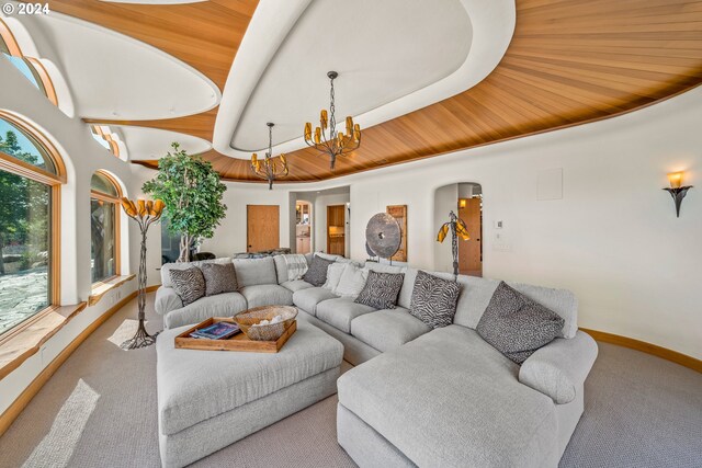 living room featuring an inviting chandelier, carpet floors, and wooden ceiling