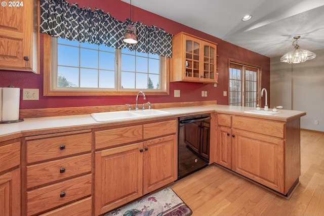 kitchen featuring pendant lighting, dishwasher, kitchen peninsula, and sink