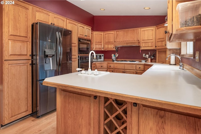 kitchen with kitchen peninsula, sink, vaulted ceiling, and black appliances