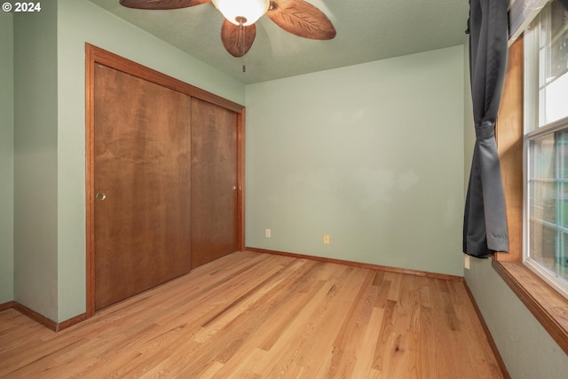 unfurnished bedroom featuring ceiling fan, light hardwood / wood-style floors, a textured ceiling, and a closet