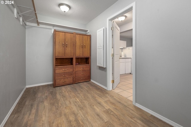 interior space with a textured ceiling and light wood-type flooring